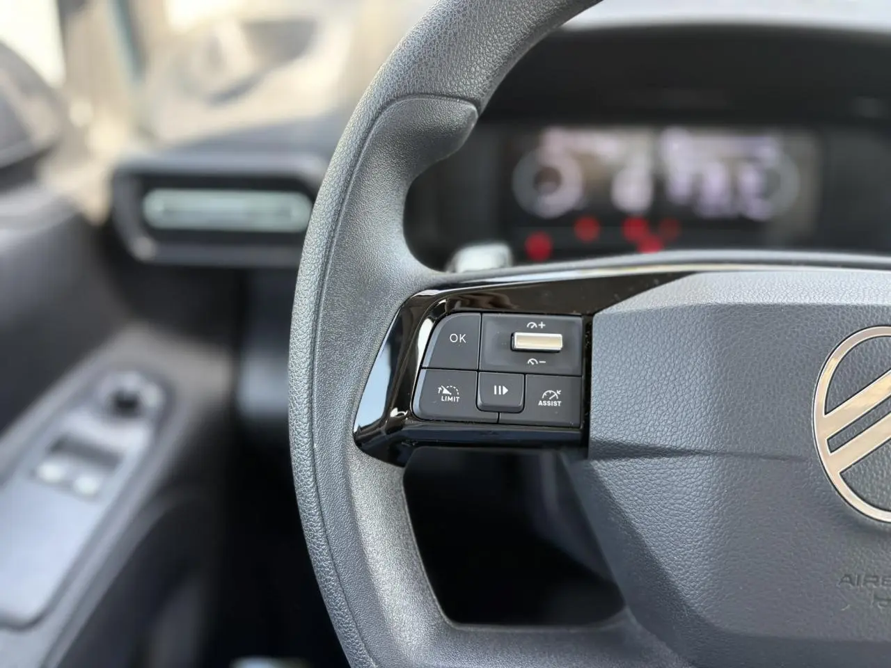 Gros plan sur le volant multifonction gris du Citroën Berlingo 2025, avec commandes de régulateur et limiteur.