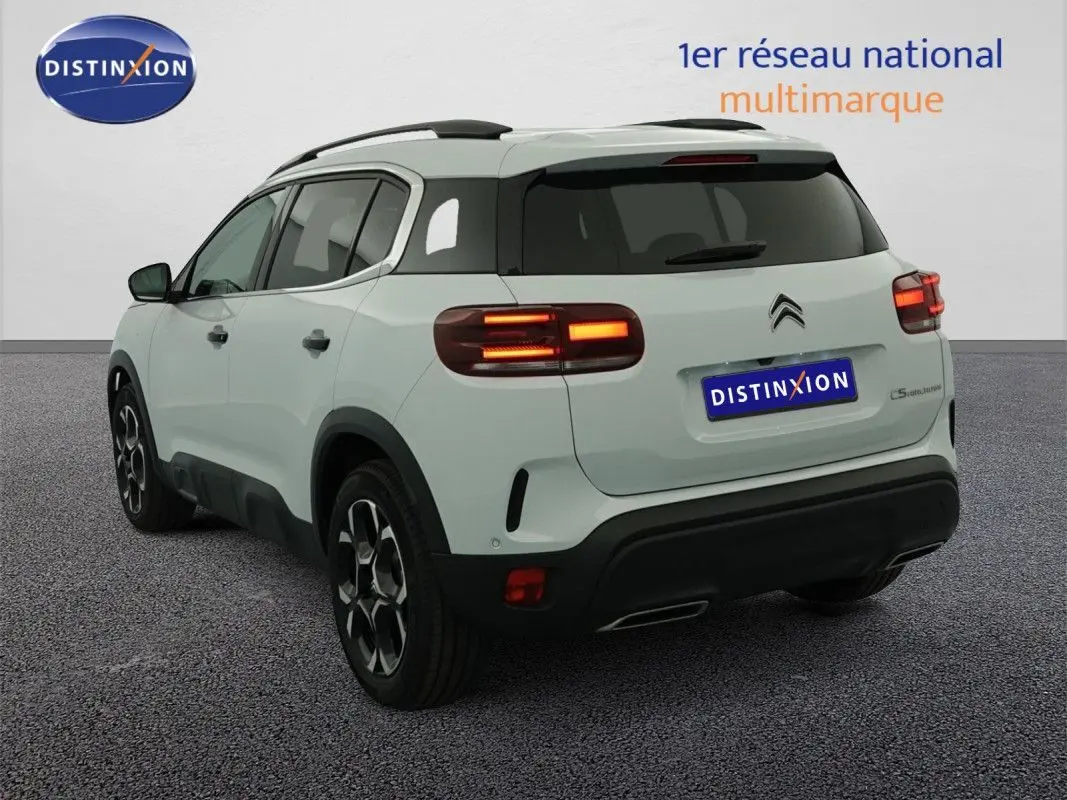 Citroën C5 Aircross blanc Okenite vue 3/4 arrière droit, feux arrière allumés et toit noir contrastant.