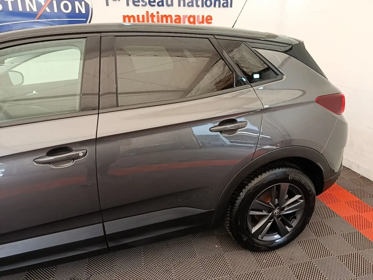Vue latérale côté droit de l’Opel Grandland X gris foncé, mettant en valeur les jantes alliage et les poignées de porte.