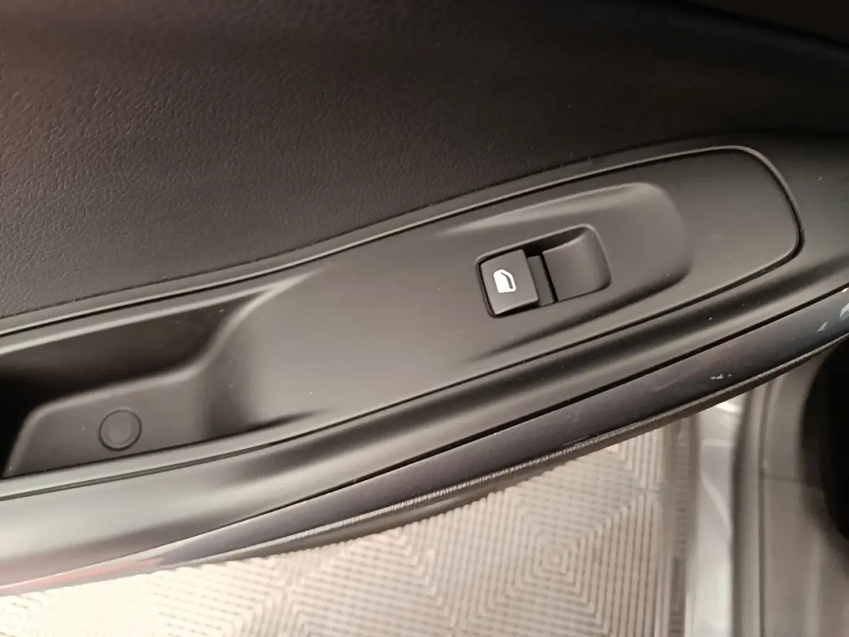Gros plan sur la commande de verrouillage des portes côté conducteur de l'Opel Grandland X gris foncé.