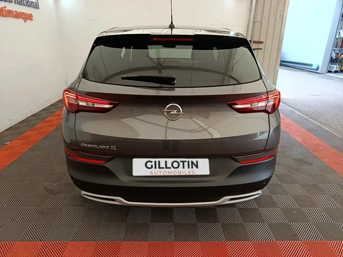 Vue arrière d'un Opel Grandland X gris foncé 2021 avec feux LED et logo central sur hayon.
