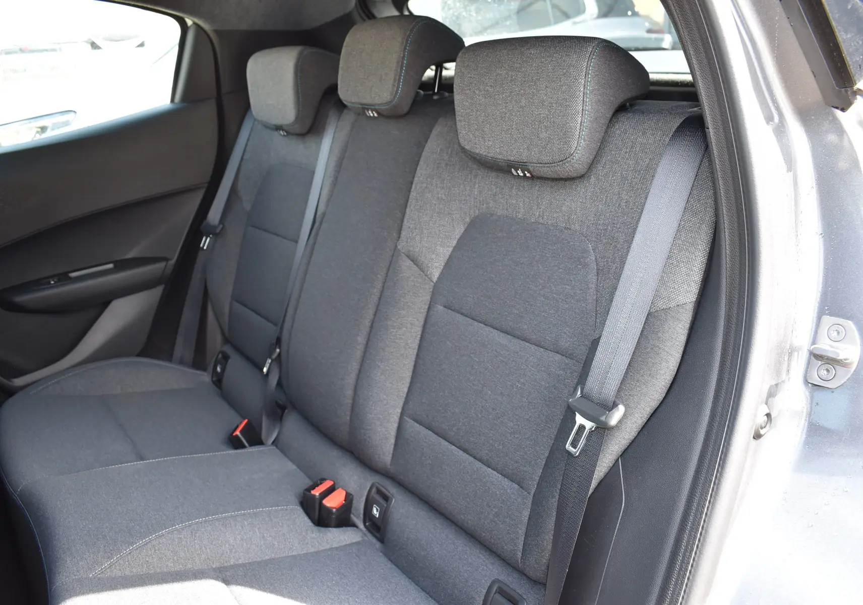 Vue côté droit de la banquette arrière gris foncé de la Renault Clio VI 2026 avec ceintures et appui-têtes intégrés.