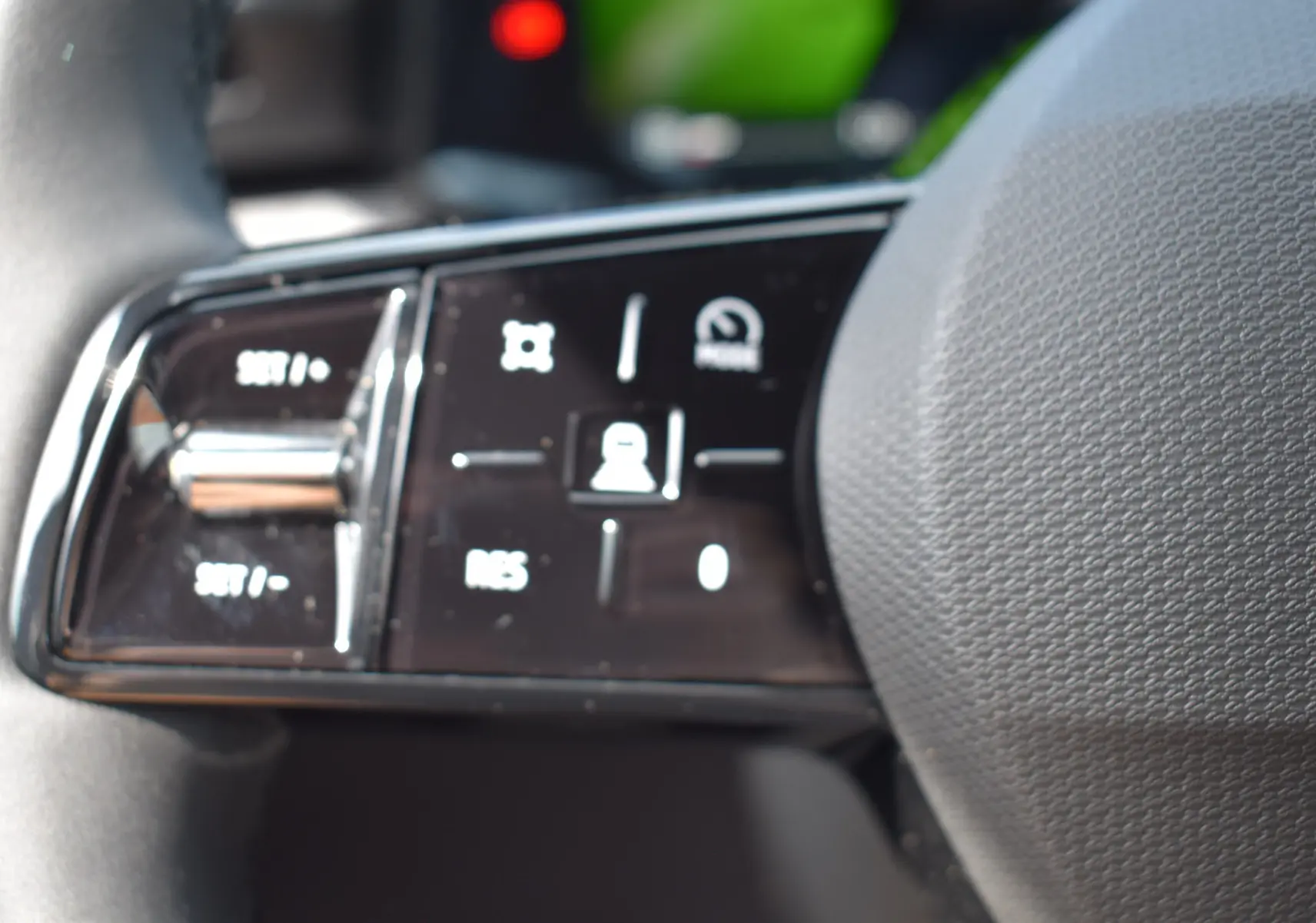 Gros plan sur les commandes au volant de la Renault Clio VI TCe 115 Evolution+ avec finition noire brillante.