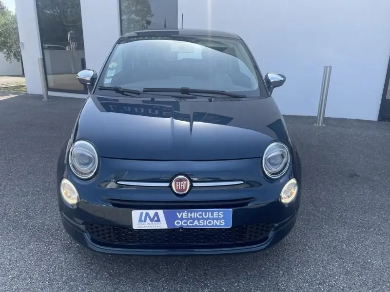 Vue frontale d'une Fiat 500 bleu foncé métal de 2016 avec phares allumés et logo FIAT visible sur la calandre.