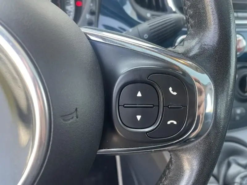 Gros plan sur les commandes du volant côté droit d'une Fiat 500 bleu foncé métal, version diesel 2016.
