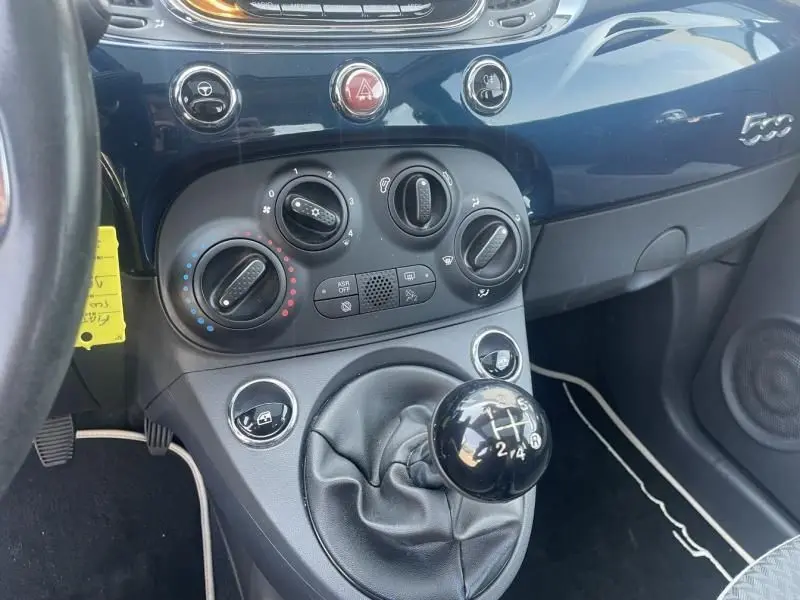 Gros plan sur la console centrale et levier de vitesse manuel d'une Fiat 500 bleu foncé métal de 2016, version Popstar.