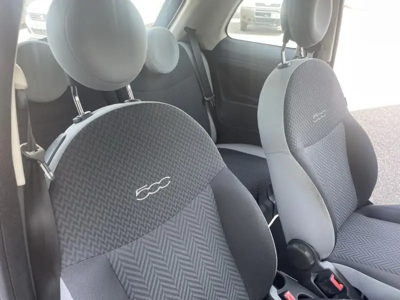 Gros plan sur les sièges avant gris foncé avec logo 500 de la Fiat 500 Popstar, intérieur sobre et moderne.