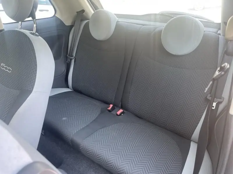 Vue intérieure arrière de la Fiat 500 2016, sièges noirs avec motifs chevrons et appuie-têtes ronds gris clair.