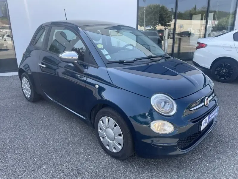 Vue 3/4 avant droite d'une Fiat 500 bleu foncé métal de 2016 avec jantes argentées et rétroviseurs chromés.