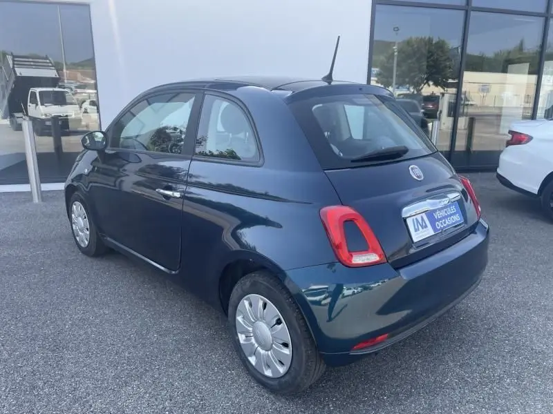 Vue 3/4 arrière droite d'une FIAT 500 bleu foncé métal de 2016, compacte avec feux arrière distinctifs et jantes argentées.