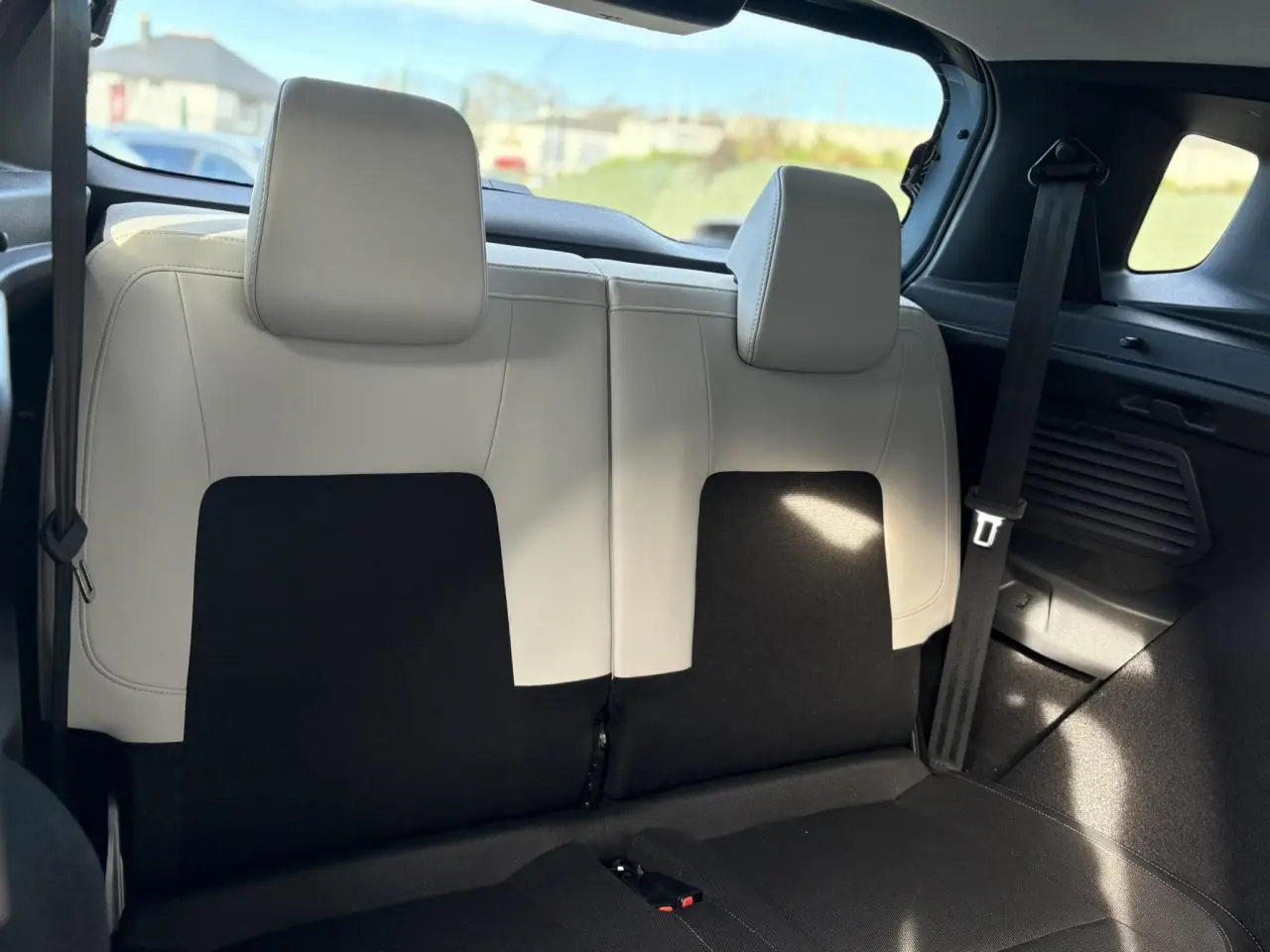 Vue arrière intérieure sur la banquette 2 places arrière bi-ton noir et gris clair du Citroën C3 Aircross Hybrid 2025.