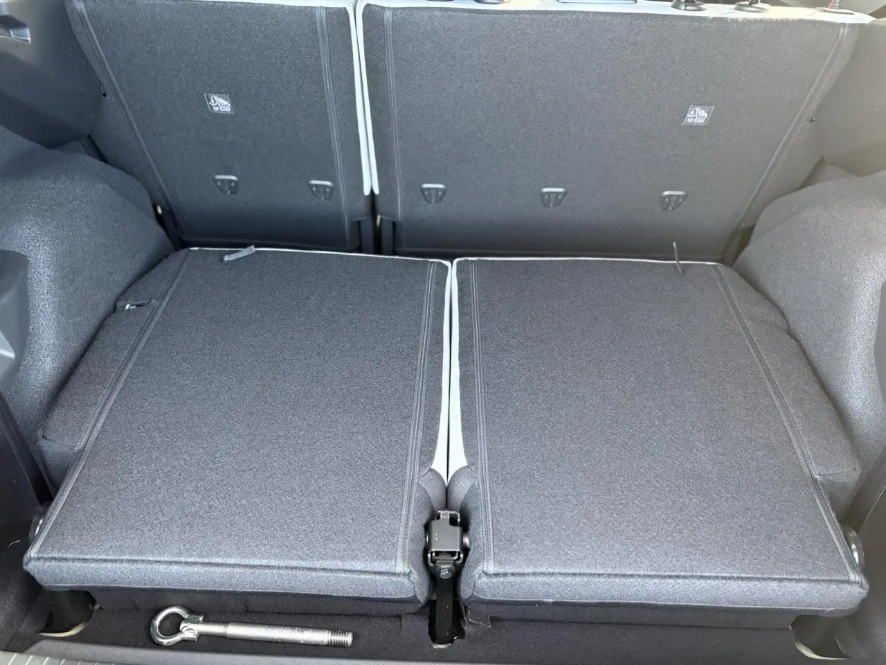 Vue du coffre avec banquette arrière rabattue en deux parties dans un Citroën C3 Aircross Hybrid 2025 bleu Monte Carlo.