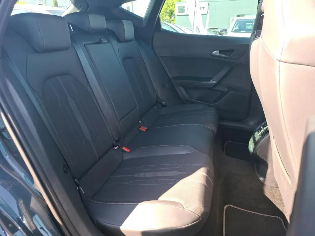 Vue intérieure côté gauche des sièges arrière en cuir noir du CUPRA Formentor gris avec finitions modernes et ceintures visibles.