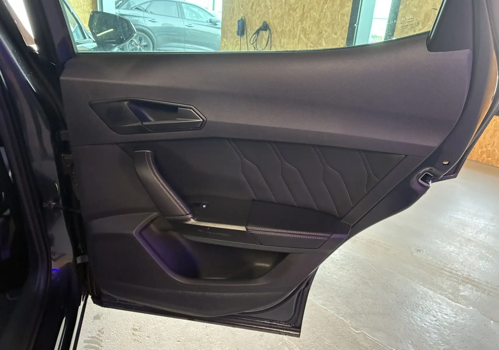 Vue intérieure de la porte arrière gauche noire du CUPRA Formentor 1.4 e-Hybrid 2023 avec surpiqûres décoratives.