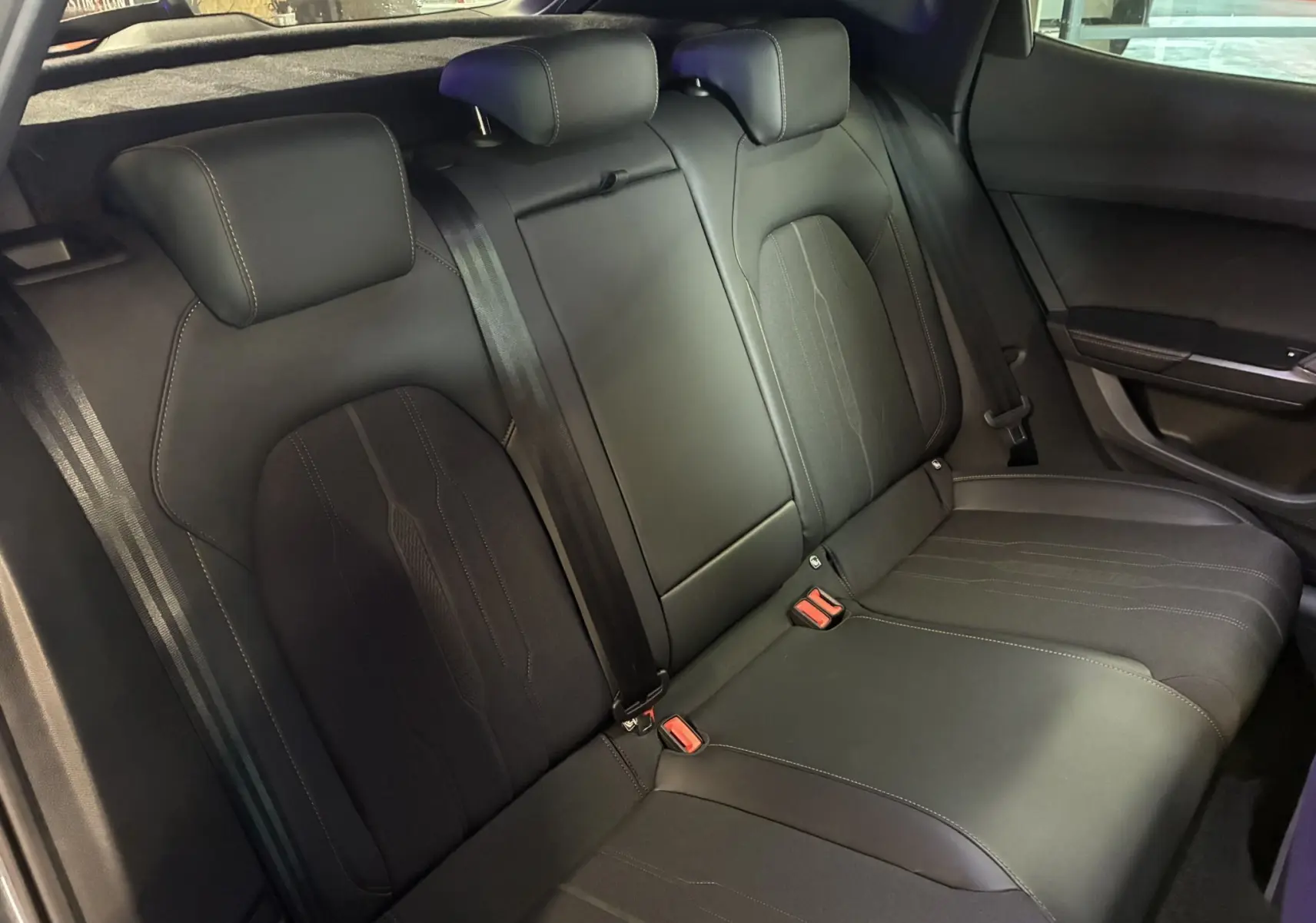 Vue intérieure des sièges arrière noirs du CUPRA Formentor 1.4 e-Hybrid 2023, avec appuie-têtes et ceintures visibles.