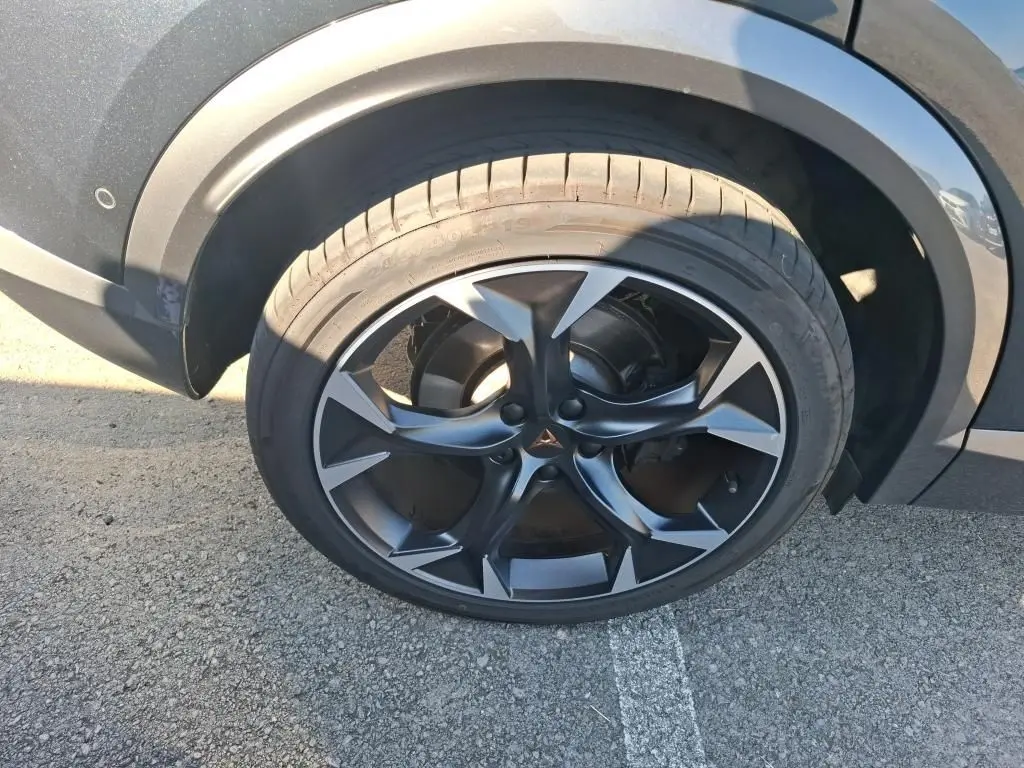 Gros plan sur la roue avant droite du CUPRA Formentor gris, mettant en valeur la jante noire et argentée au design sportif.