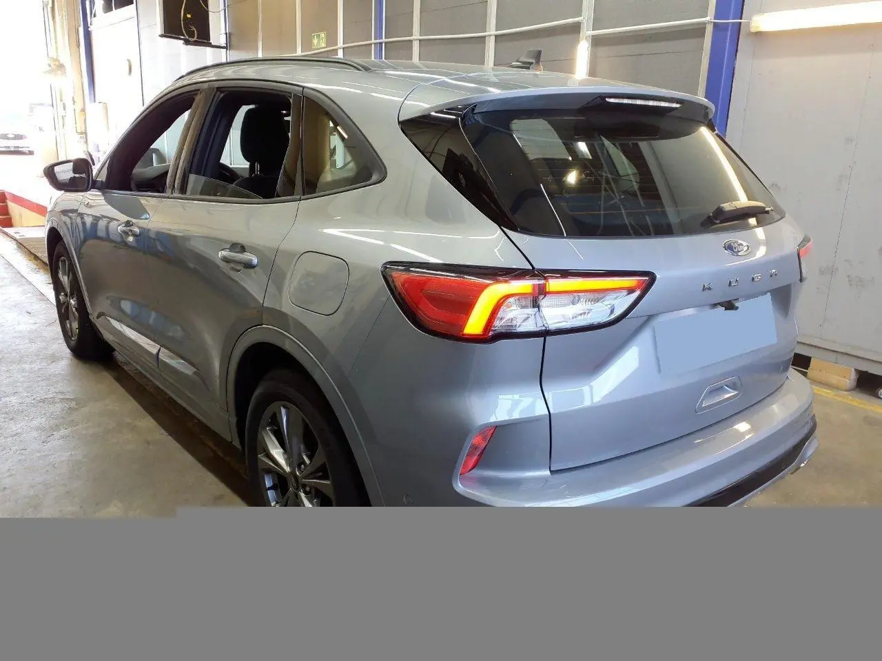 Vue 3/4 arrière droite du Ford Kuga gris Solar 2024 avec feux LED allumés et jantes alliage 18 pouces.