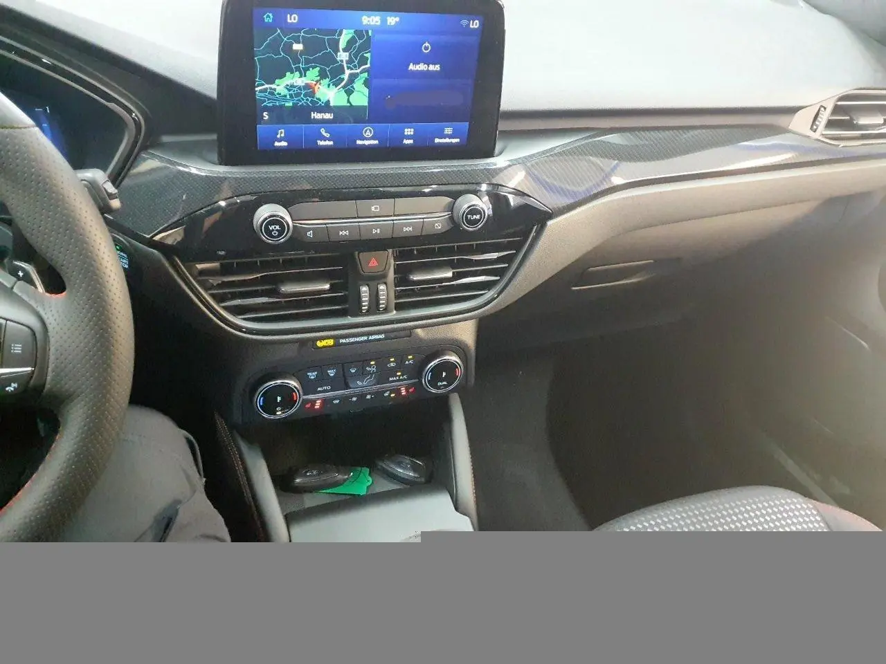 Vue intérieure du tableau de bord du Ford Kuga 2024, avec écran tactile GPS et commandes climatisation visibles.