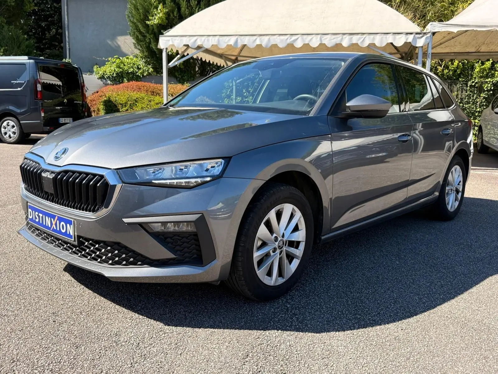 SKODA SCALA gris graphite en 3/4 avant droit, mettant en valeur sa calandre noire et ses optiques fines.