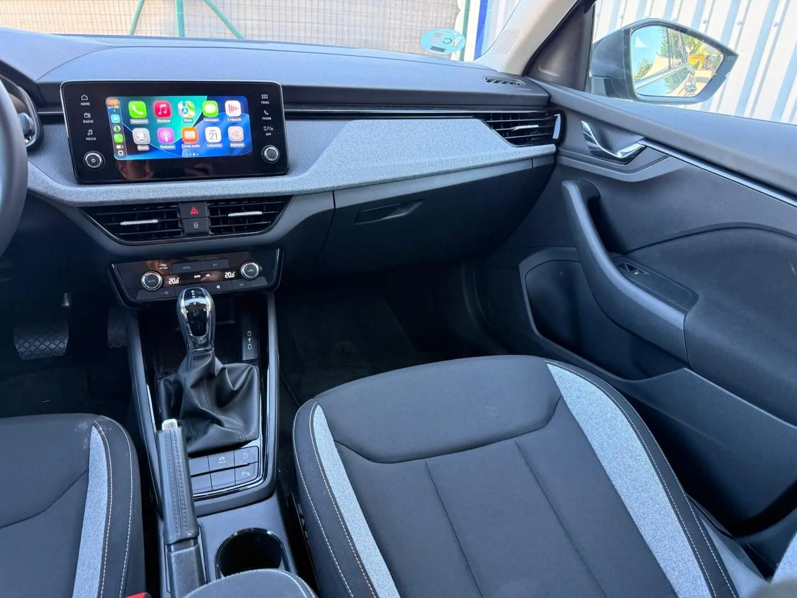 Vue intérieure côté passager de la Skoda Scala 2025, avec sellerie noire et grise et écran tactile central lumineux.