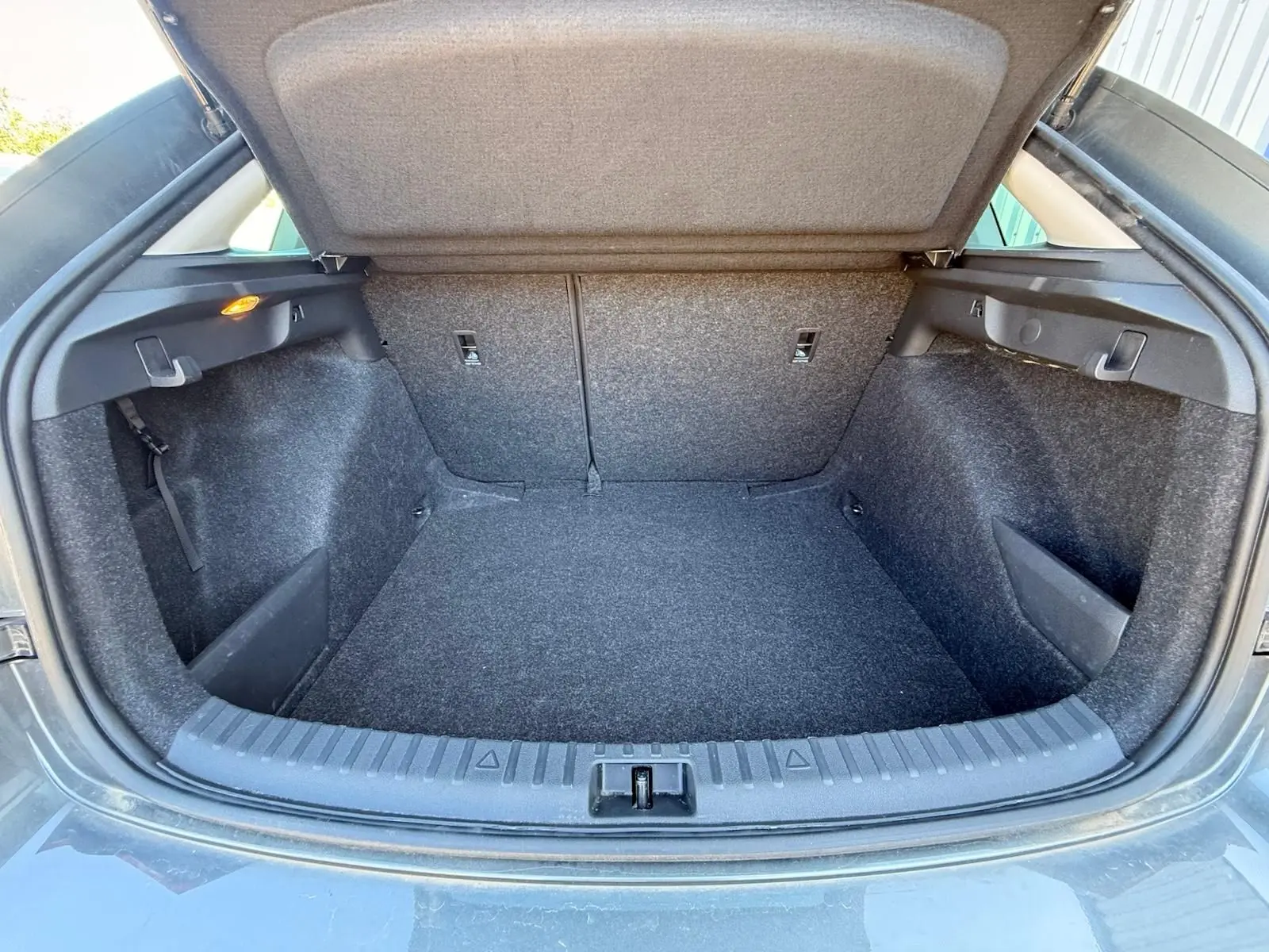 Coffre ouvert vu de l'arrière d'une Skoda Scala gris graphite 2025, montrant un espace de chargement propre et spacieux.