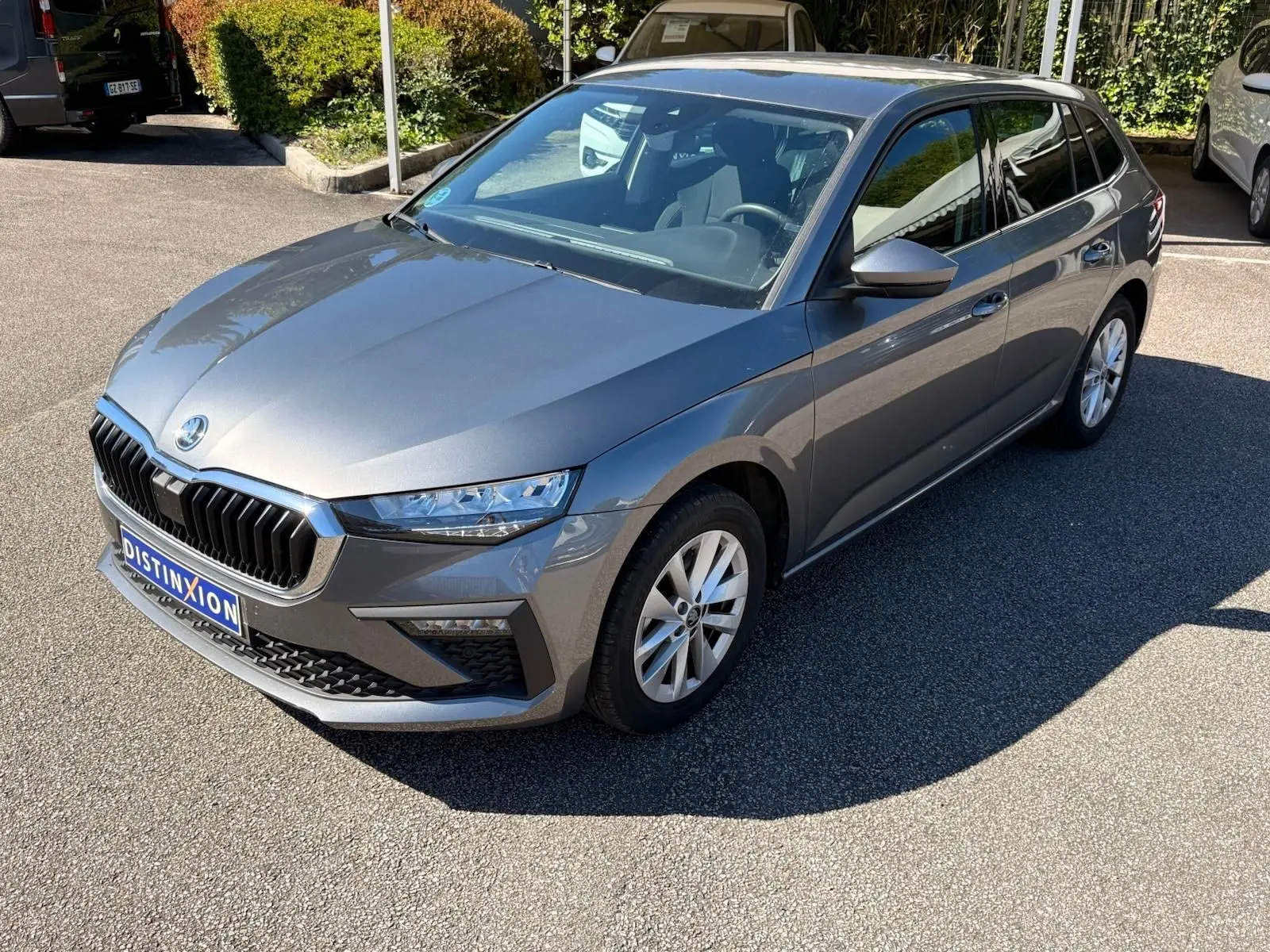 Vue 3/4 avant droite d'une Skoda Scala gris graphite 2025 avec calandre noire et jantes alliage.