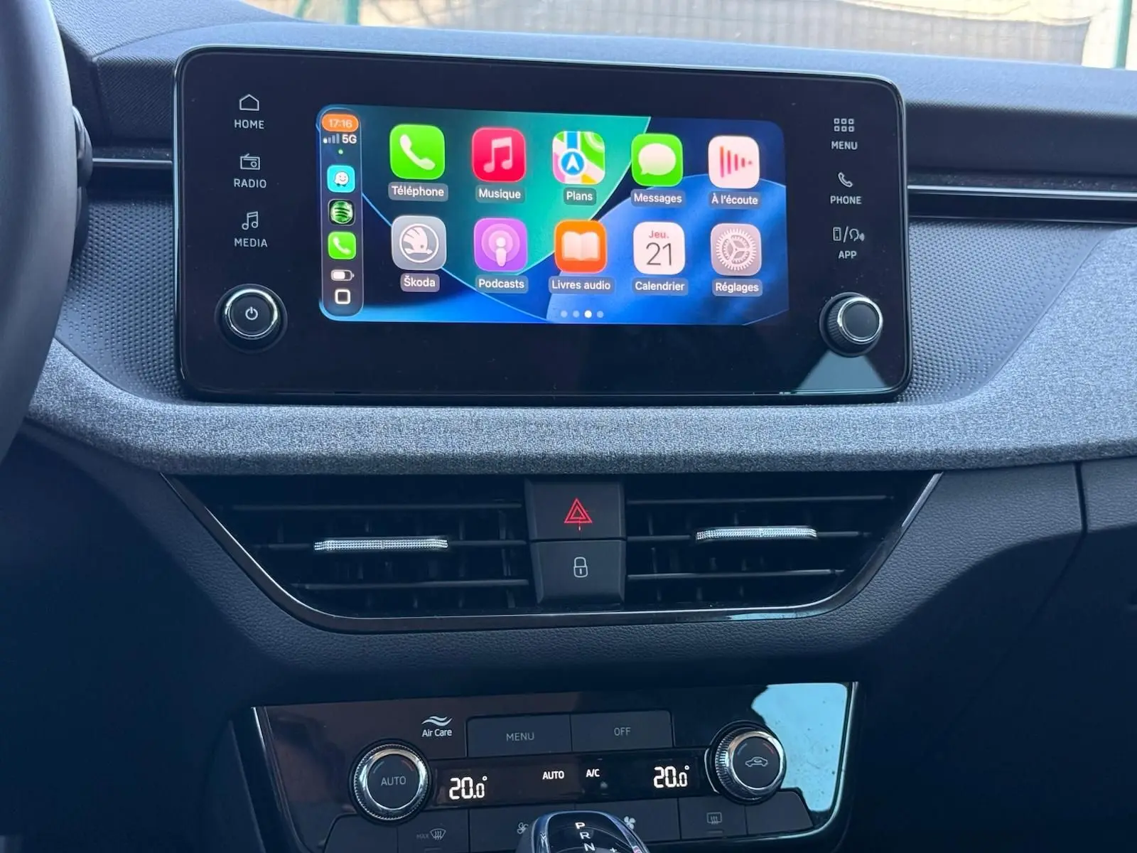 Intérieur de la Skoda Scala 2025 en gris graphite, vue sur l’écran tactile central et la console de climatisation.