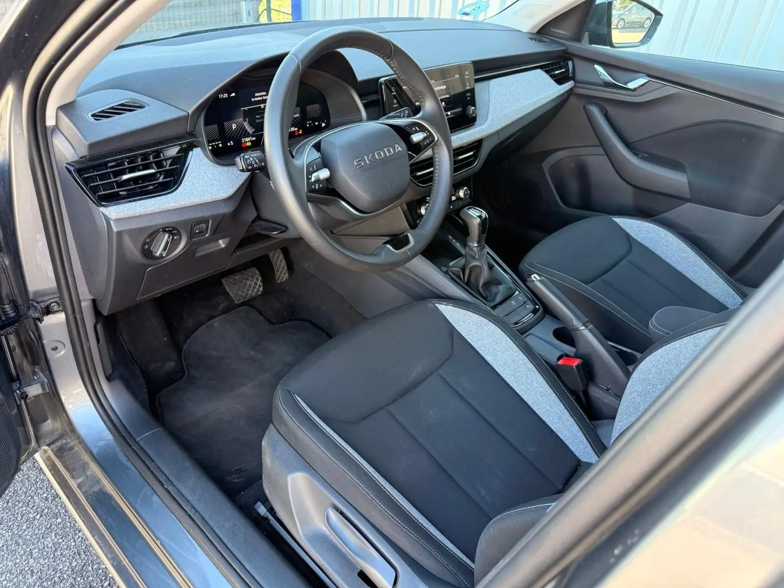 Intérieur avant droit d’une Skoda Scala gris graphite 2025, volant multifonction, sièges tissu bicolore et boîte auto DSG7.
