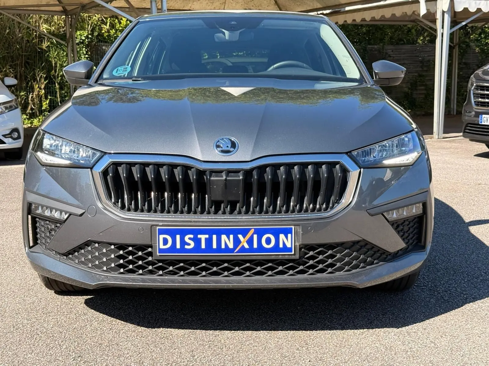 Vue frontale d'une Skoda Scala gris graphite 2025 avec calandre noire et phares LED distinctifs.