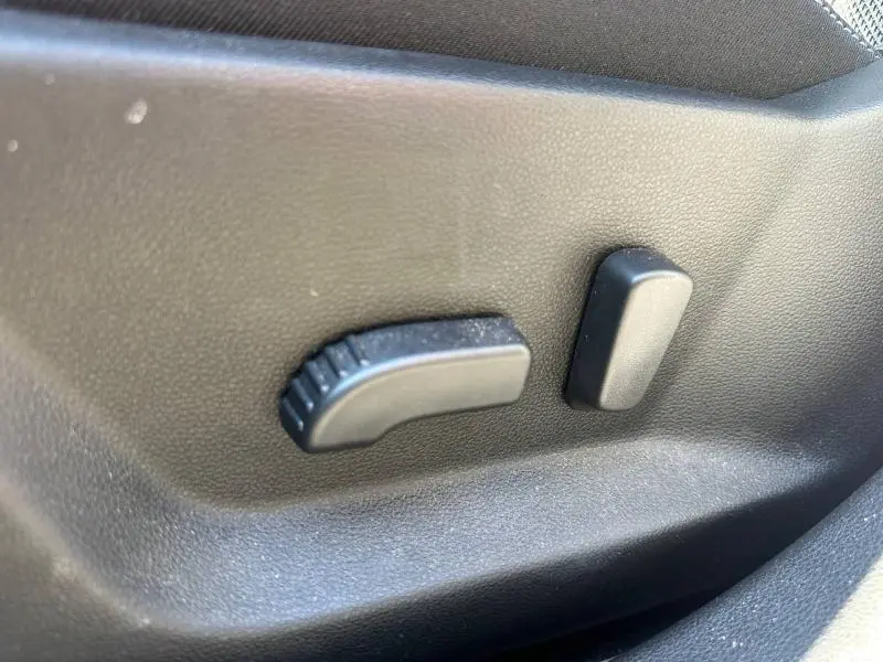 Gros plan sur les commandes de réglage électrique du siège côté conducteur du Dacia Bigster gris Schiste.