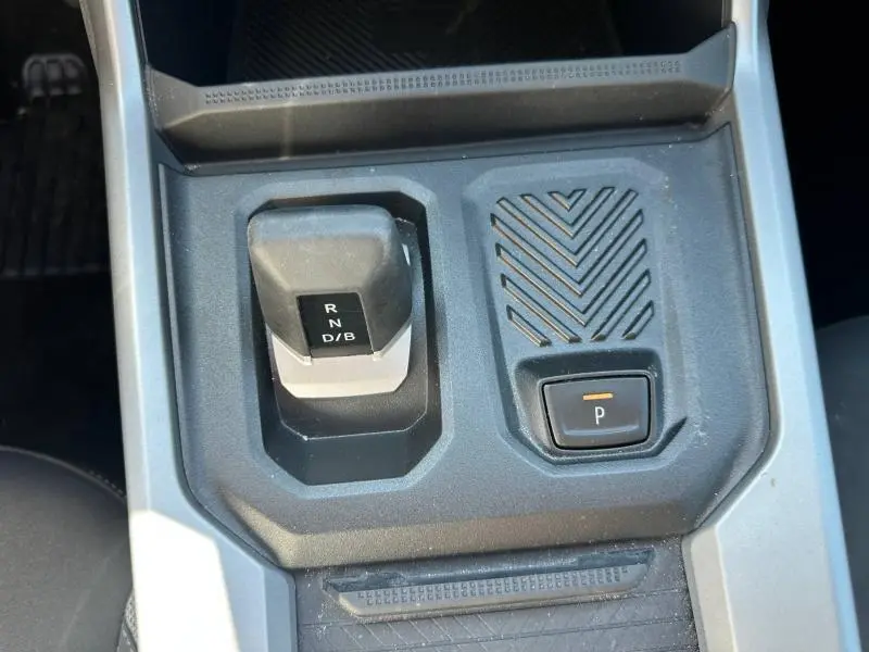 Gros plan sur la console centrale du Dacia Bigster gris schiste, montrant le levier de vitesse automatique et le bouton de stationnement.