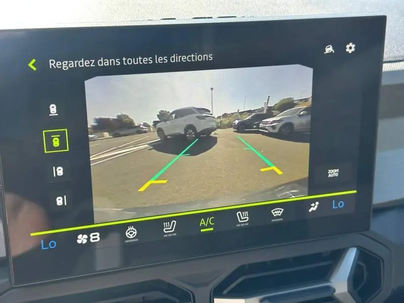 Écran tactile intérieur montrant la caméra de recul du Dacia Bigster gris schiste avec lignes de guidage vertes et jaunes.