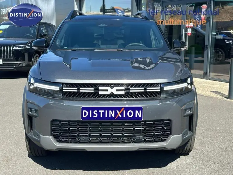 Vue de face du Dacia Bigster 1.8 hybrid gris schiste avec calandre noire et logo central distinctif.