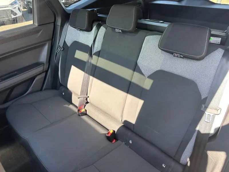 Vue intérieure de la banquette arrière gris foncé et gris clair du Dacia Bigster 2025 avec appuie-têtes et ceintures visibles.