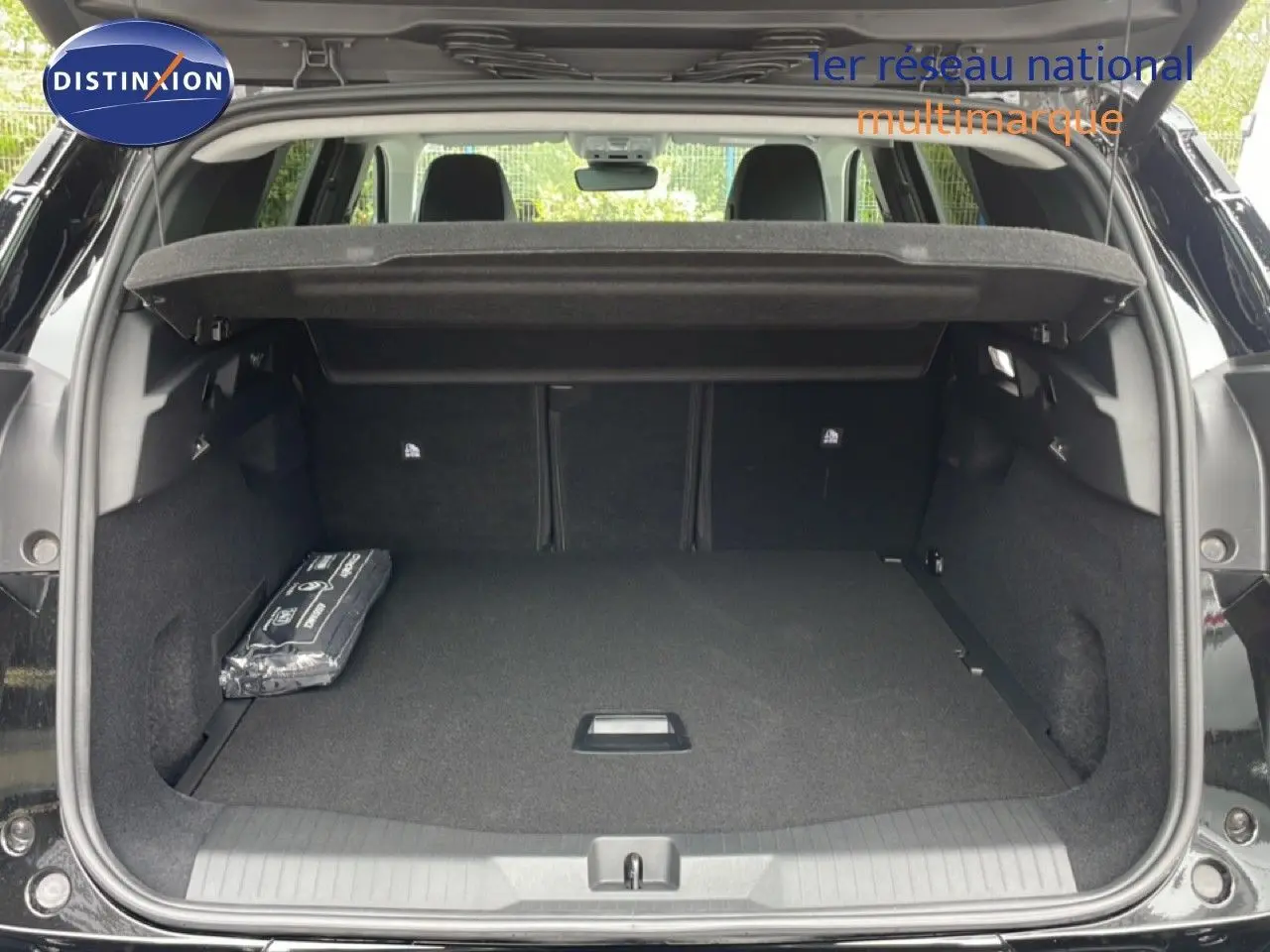 Coffre ouvert en vue arrière d’un Citroën C5 Aircross noir Perla Nera, montrant un espace de chargement spacieux et un cache-bagages relevé.