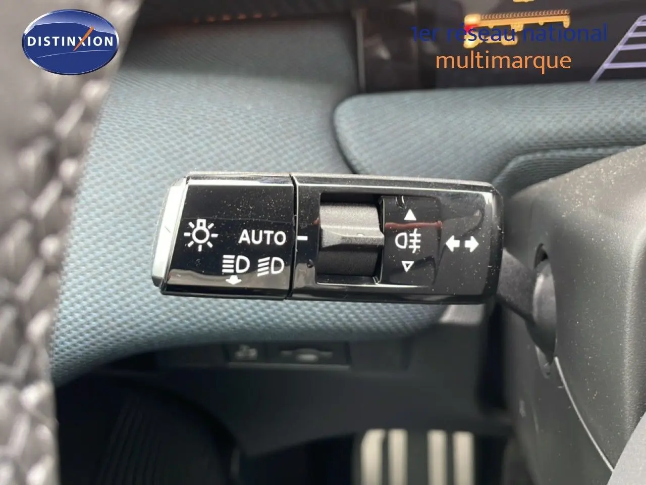 Gros plan sur la commande des feux et clignotants du Citroën C5 Aircross noir Perla Nera, intérieur tissu gris-noir.