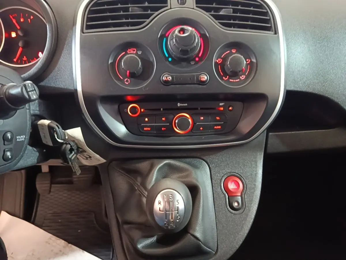 Vue rapprochée du tableau de bord et levier de vitesses manuel du Renault Kangoo 2020, commandes clim et audio visibles.