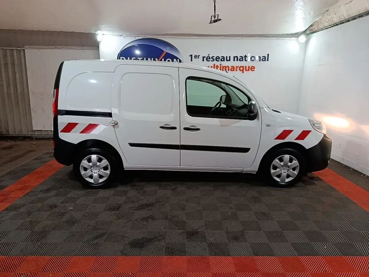 Profil droit d'un Renault Kangoo blanc 2020 avec bandes réfléchissantes rouges sur ailes avant et arrière.