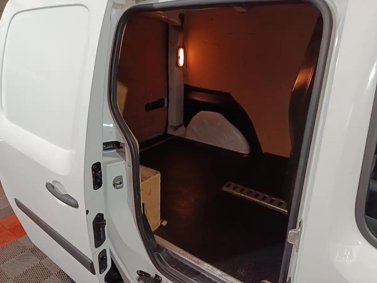 Vue intérieure côté droit du Renault Kangoo blanc 2020, montrant l’espace de chargement vide avec cloison pleine.