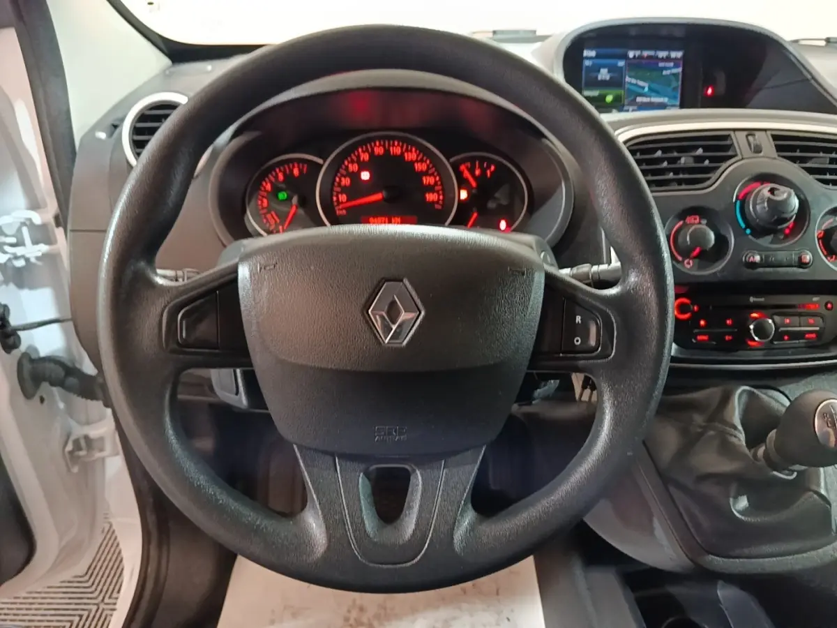 Vue intérieure centrée sur le volant noir de Renault Kangoo blanc 2020 avec tableau de bord et levier de vitesses manuel.