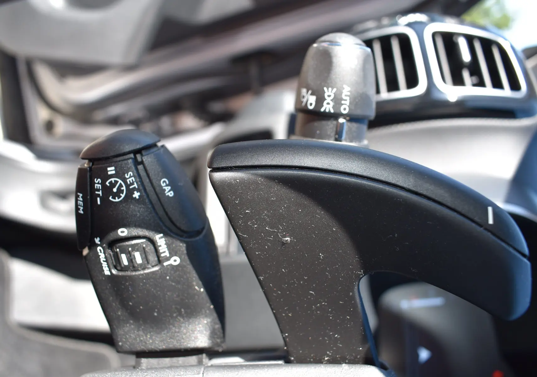 Gros plan sur la commande de régulateur de vitesse et limiteur du Citroën C5 Aircross 2024, intérieur noir.