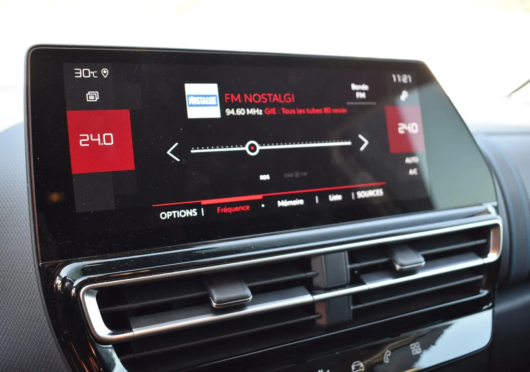 Écran tactile central du tableau de bord du Citroën C5 Aircross 2024 affichant la radio FM sur fond noir brillant.