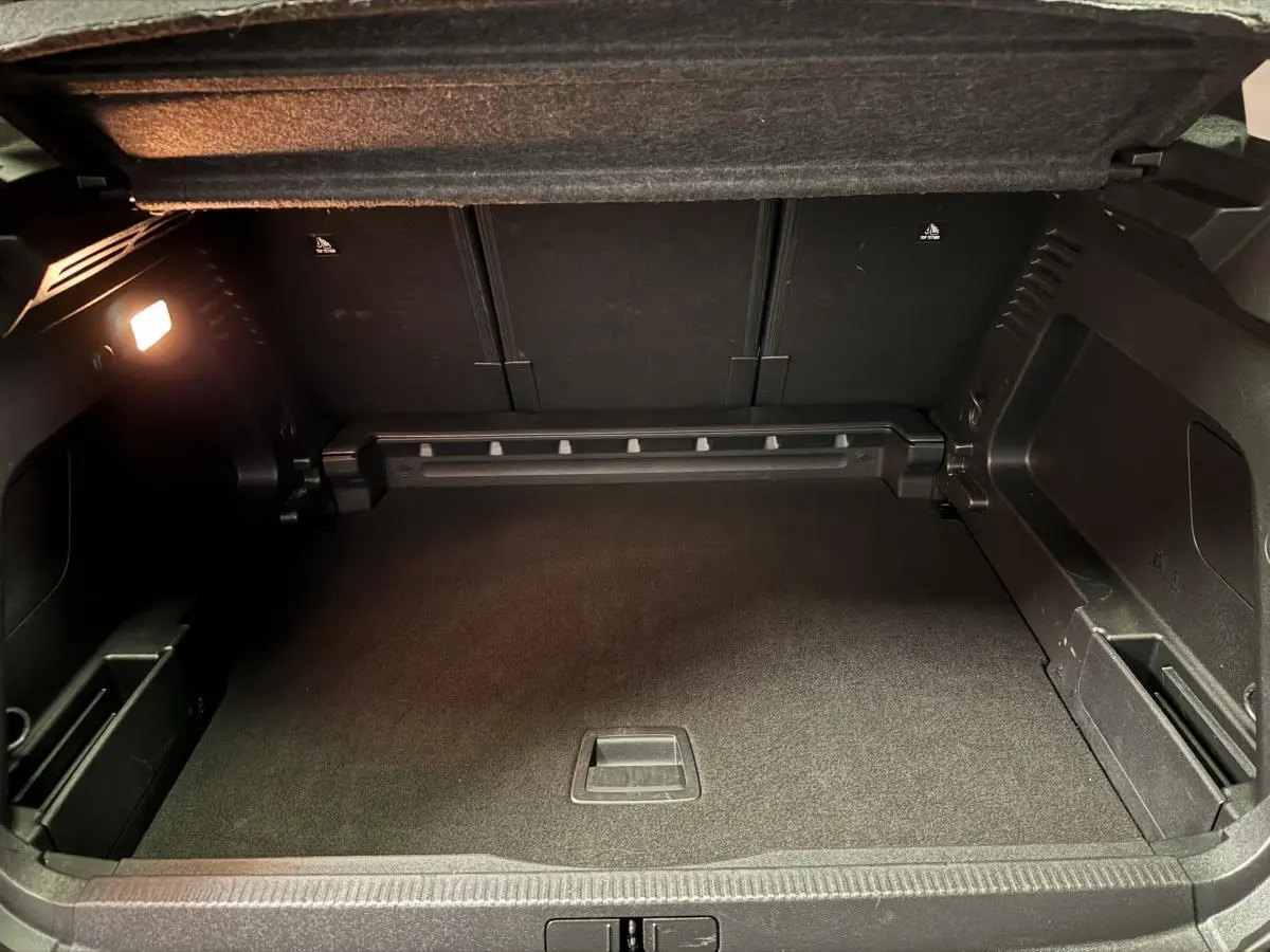 Coffre spacieux ouvert du Citroën C5 Aircross noir, montrant le plancher plat et les rangements latéraux intégrés.