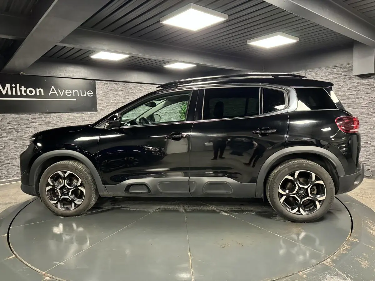 Profil côté gauche du Citroën C5 Aircross noir nacré avec jantes bi-ton et barres de toit noir brillant.