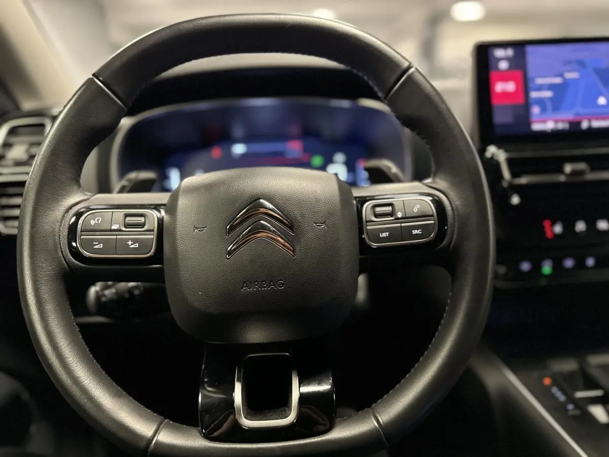 Volant en cuir noir avec logo Citroën, vue frontale du poste de conduite du C5 Aircross 2022 avec écran tactile visible.