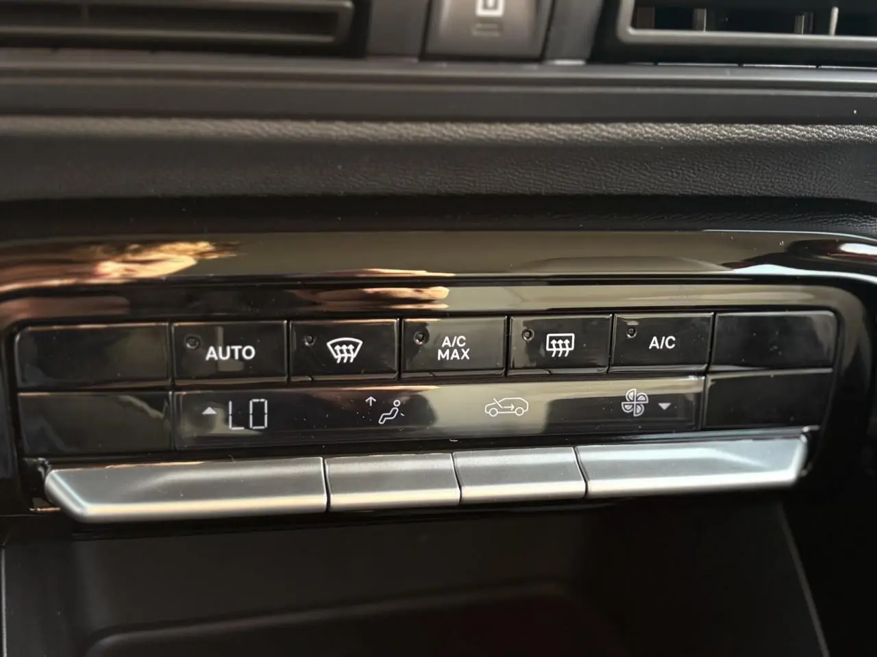Gros plan sur les commandes de climatisation automatique noire et argentée du tableau de bord du Citroën C3 Aircross Hybrid 2025.