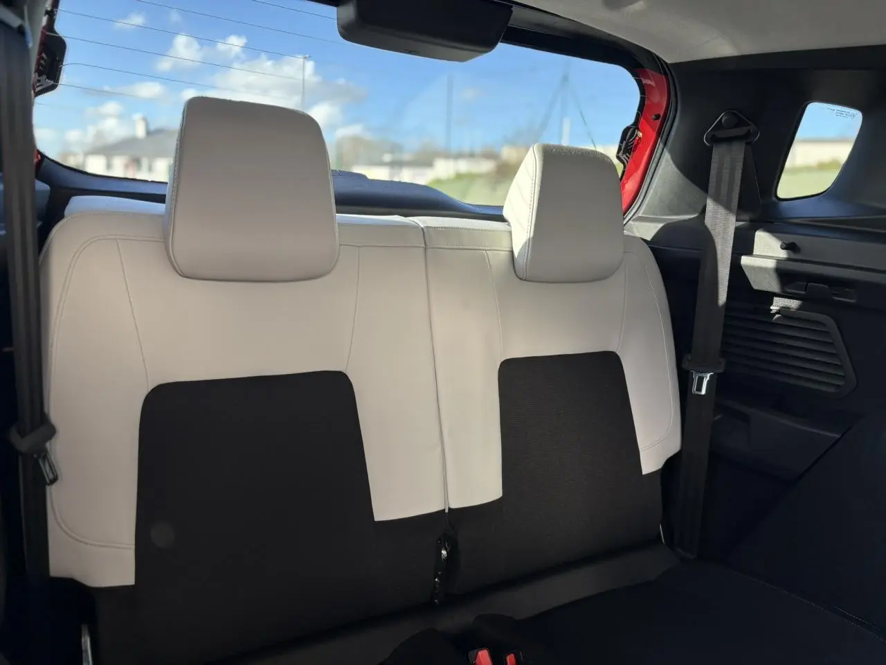 Vue arrière intérieure sur la banquette 2 places arrière en cuir clair et tissu noir du Citroën C3 Aircross Rouge Elixir.