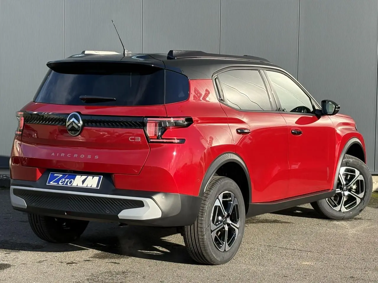 Vue 3/4 arrière droite du Citroën C3 Aircross Hybrid rouge Elixir avec toit noir et jantes alliage 17 pouces.