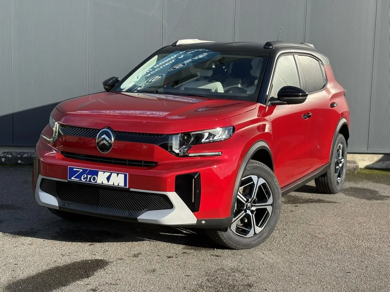 Vue 3/4 avant droite du Citroën C3 Aircross rouge Elixir avec toit noir et jantes alliage 17 pouces.