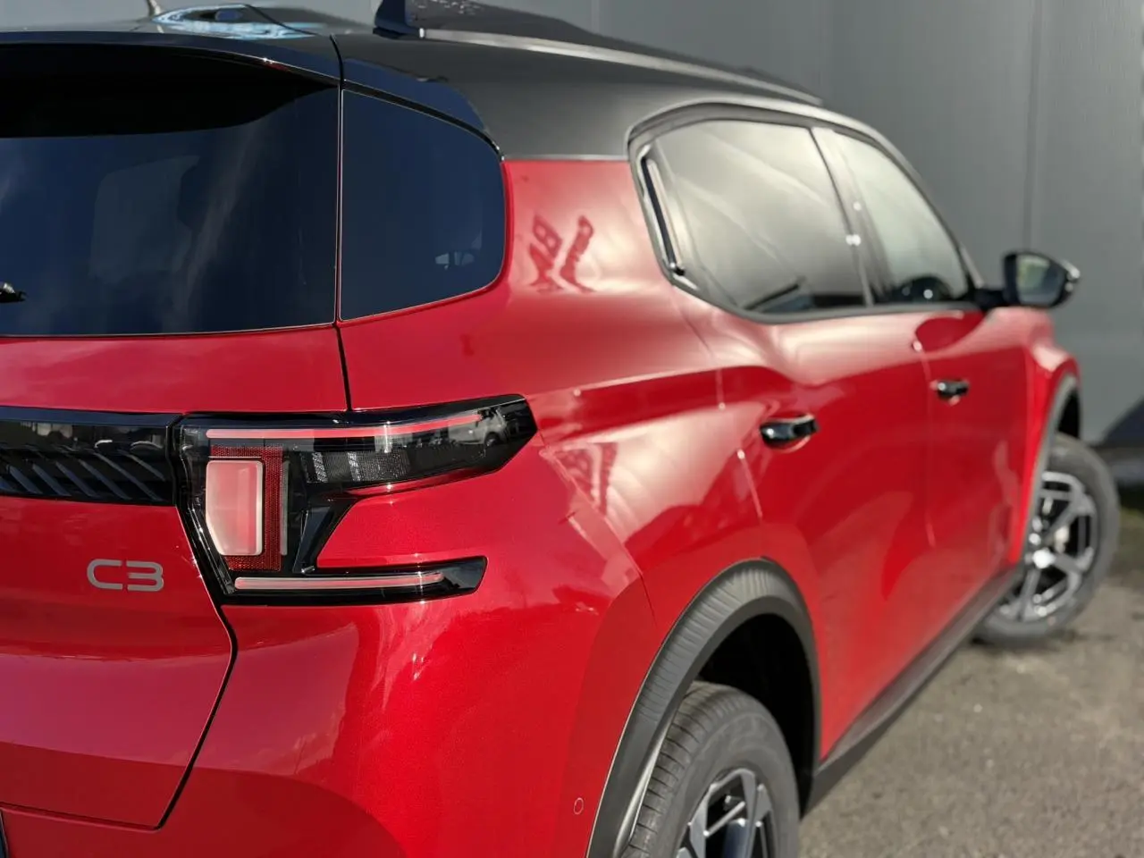 Vue 3/4 arrière droite du Citroën C3 Aircross rouge Elixir avec toit noir et feux arrière LED distinctifs.